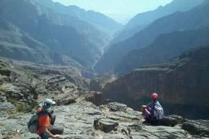 Des randonneurs contemplant une vallée depuis le plateau du Jebel Akhdar.