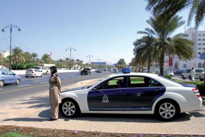 Policewomen of the Royal Oman Police watching the Sultan Qaboos Street in Muscat.
