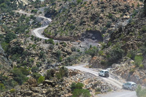 Cars on the dirt road crossing the Western Hajar mountain range.